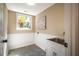 Bright laundry room features wainscoting, gray tile flooring, white cabinets, and a large window at 103 Windhover Dr, Chapel Hill, NC 27514