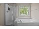 Bright bathroom featuring a walk-in shower, large window, and a soaking tub at 104 Dallavia Ct, Morrisville, NC 27560