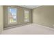 Carpeted bedroom with natural light from two windows at 104 Dallavia Ct, Morrisville, NC 27560