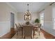 Elegant dining room showcasing a chandelier, wainscoting, and hardwood floors with an area rug at 104 Dallavia Ct, Morrisville, NC 27560
