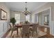 Dining room featuring hardwood floors, wainscoting, an elegant chandelier, and window views at 104 Dallavia Ct, Morrisville, NC 27560