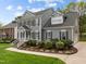 Charming gray home with manicured landscaping, brick steps and black shutters at 104 Dallavia Ct, Morrisville, NC 27560