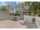 A beautiful backyard gazebo sits on a wooden deck surrounded by a white picket fence at 104 Dallavia Ct, Morrisville, NC 27560