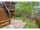 Backyard featuring a brick patio, wood deck with stairs, and a spacious yard with trees at 109 Homegate Cir, Apex, NC 27502