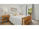 Bright bedroom features a wooden bed frame, neutral walls, and natural light from the large window at 109 Homegate Cir, Apex, NC 27502