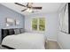 Bright bedroom with a ceiling fan, black headboard, neutral walls, and natural light from the window at 109 Homegate Cir, Apex, NC 27502