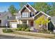 Charming home featuring a stone facade, red front door, manicured lawn, and colorful landscaping at 109 Homegate Cir, Apex, NC 27502