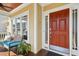 Inviting covered front porch featuring a red front door, bench seating, and decorative foliage at 109 Homegate Cir, Apex, NC 27502