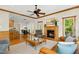 Open concept living room featuring a fireplace, hardwood floors, and a seamless flow to dining and kitchen at 109 Homegate Cir, Apex, NC 27502