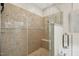 Modern bathroom with glass shower enclosure, built in bench and beautiful neutral stone at 109 Homegate Cir, Apex, NC 27502