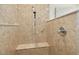 Close-up of shower with built-in bench and natural stone tile at 109 Homegate Cir, Apex, NC 27502