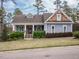 Charming home featuring a landscaped front yard and welcoming covered porch with stone accents on the columns at 110 Streamside Dr, Sanford, NC 27330