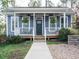 Charming home with a welcoming front porch, adorned with hanging plants and a wreath on the door at 110 Streamside Dr, Sanford, NC 27330