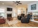 Cozy living room with a fireplace, large windows, and comfortable leather seating at 110 Streamside Dr, Sanford, NC 27330