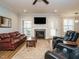 Inviting living room featuring a fireplace, ceiling fan, and ample seating for entertaining at 110 Streamside Dr, Sanford, NC 27330