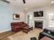 Comfortable living room with a fireplace, leather couch, and a view of the doorway at 110 Streamside Dr, Sanford, NC 27330
