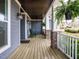 Inviting covered porch with stone columns, hanging ferns, and rocking chairs, perfect for outdoor relaxation at 110 Streamside Dr, Sanford, NC 27330