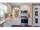 Modern kitchen features white cabinets, stainless steel appliances, and an open archway at 111 Fox View Pl, Cary, NC 27511