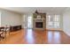 Bright living room featuring a brick fireplace, hardwood floors, ceiling fan and French doors to a deck at 111 Fox View Pl, Cary, NC 27511