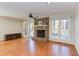 Bright living room featuring a brick fireplace, hardwood floors, ceiling fan and French doors to a deck at 111 Fox View Pl, Cary, NC 27511