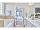 Bright bathroom featuring a large soaking tub and double vanity, with a doorway leading to the bedroom at 1112 Addington Lake Ln, Knightdale, NC 27545