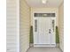 Inviting front entrance with a classic white door, sidelights and decorative potted plants at 1112 Addington Lake Ln, Knightdale, NC 27545