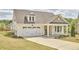 Beautiful home featuring a two-car garage, manicured lawn and covered front porch with seating at 1112 Addington Lake Ln, Knightdale, NC 27545