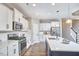 Bright kitchen with white cabinets and island with seating open to dining area at 1112 Addington Lake Ln, Knightdale, NC 27545