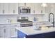 A well-lit kitchen featuring white cabinets, stainless steel appliances, and modern fixtures at 1112 Addington Lake Ln, Knightdale, NC 27545