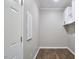 Neat laundry room with wood floors, white cabinets, and a door to adjacent room at 1112 Addington Lake Ln, Knightdale, NC 27545