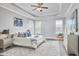 Bright main bedroom featuring a tray ceiling, ceiling fan, and seating area at 1112 Addington Lake Ln, Knightdale, NC 27545