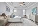Bright main bedroom featuring a tray ceiling, ceiling fan, and seating area at 1112 Addington Lake Ln, Knightdale, NC 27545