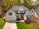 Aerial view of a lovely home with green lawn, mature trees, and paved driveway at 113 Glenmore Rd, Chapel Hill, NC 27516