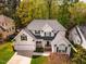 Aerial view of a well-kept home featuring a green lawn, a paved driveway, and trees at 113 Glenmore Rd, Chapel Hill, NC 27516