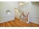 Bright foyer boasts hardwood floors, elegant staircase with white banister, and stylish circular mirror at 113 Glenmore Rd, Chapel Hill, NC 27516