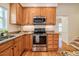 Well-lit kitchen with stainless steel appliances, custom cabinets, and granite countertops at 113 Glenmore Rd, Chapel Hill, NC 27516