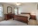 Bright main bedroom with large windows, ceiling fan, carpet, wood furniture, and natural light at 113 Glenmore Rd, Chapel Hill, NC 27516