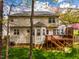 Exterior view of a home with a wooden deck, siding, and surrounded by mature trees and lawn at 113 Glenmore Rd, Chapel Hill, NC 27516