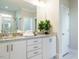 Bright bathroom featuring double sinks, granite countertops, white cabinets, and a decorative green plant at 113 Tower Ridge Ln, Sanford, NC 27330