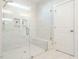 Luxurious walk-in shower with marble-style tile, a built-in bench, and a glass door, with a white door nearby at 113 Tower Ridge Ln, Sanford, NC 27330