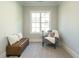 Cozy bedroom featuring a leather bench and chair, complemented by plush pillows and natural light from the window at 113 Tower Ridge Ln, Sanford, NC 27330