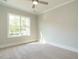 Bright and airy bedroom featuring a large window, neutral paint, carpet, and a ceiling fan at 113 Tower Ridge Ln, Sanford, NC 27330