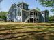 Back exterior view of a two-story house with blue siding, green grass, and a screened porch at 113 Tower Ridge Ln, Sanford, NC 27330