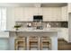 Bright kitchen with white cabinets, granite countertops, stainless steel appliances and a kitchen island with bar stools at 113 Tower Ridge Ln, Sanford, NC 27330