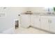 Convenient laundry room featuring white cabinets, granite countertops, and a tile floor for functionality and style at 113 Tower Ridge Ln, Sanford, NC 27330