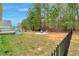Expansive backyard featuring a deck, firepit, swing set, mature trees, and an elegant black fence at 114 Carriage Hill Dr, Stem, NC 27581