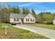 Inviting one-story home featuring a long driveway and a spacious, well-maintained front yard at 114 Carriage Hill Dr, Stem, NC 27581