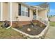 Attractive home exterior with brick accents, flower beds, and landscaped front entrance at 114 Carriage Hill Dr, Stem, NC 27581