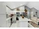 Bright kitchen boasts white cabinets, stainless steel appliances, and a center island with barstool seating at 114 Carriage Hill Dr, Stem, NC 27581