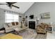 Comfortable living room with a fireplace, large windows, and cozy seating arrangement at 114 Carriage Hill Dr, Stem, NC 27581